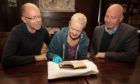 The Ackermann booklet being viewed by (left to right) Paul Adair, Margaret Borland-Stroyan and Roben Antoniewicz.