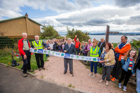 The ribbon cutting was performed by Colin McPhail (former chair of Dalgety Bay Community Council). On the left is (left to right) Dick Alderson (Committee Member of Dalgety Bay Community Woodlands Group) and David MacLeod (Chair of Dalgety Bay Community Woodlands Group). On the right with high-vis is Kathryn Green (Secretary of Dalgety Bay Community Woodlands Group).