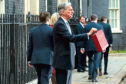 Chancellor of the Exchequer, Philip Hammond, presents the red Budget Box as he departs 11 Downing Street to deliver his 2018 budget announcement to Parliament.