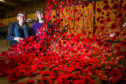 Stewart and Rebekah Lennon attaching poppies to netting to make up part of the Remembrance day display.