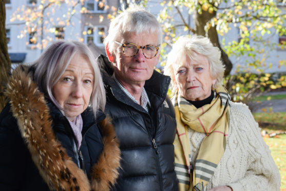 Action group members Sandra Stewart and Eric Lewis, and Scholars Gate representative Joyce Izatt beside the trees which may be removed to make way for a hotel.