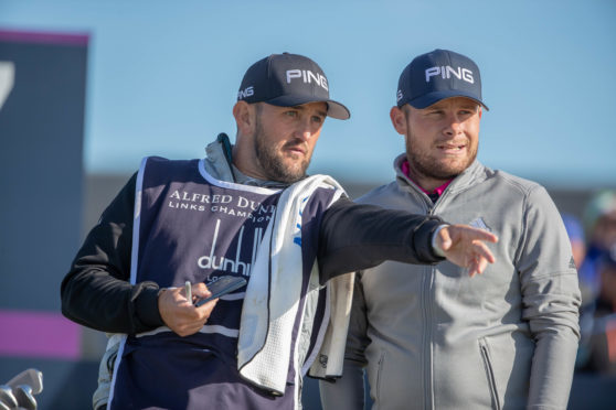 Tyrrell Hatton (r) and Scottish caddie Mark Crane plot their way to a 66 at Carnoustie yesterday.