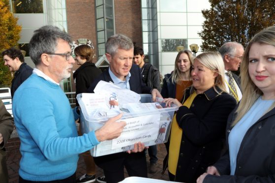 Mr Rennie, centre, and Daryl Wilson of Anstruther Community Council had over the petition to Simon Little