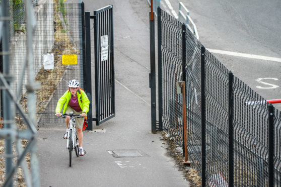 A cyclist entering the Dundee Docks section of the cycle path.