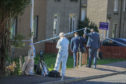 Detectives arrive at the flat in Rintoul Avenue.