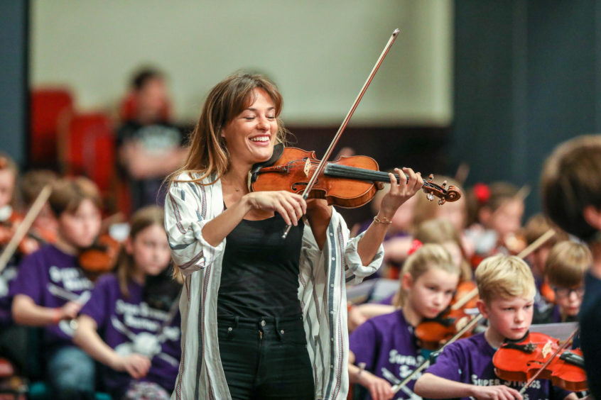 Violinist Nicola Benedetti playing with youngsters in the Big Noise Douglas orchestra.
