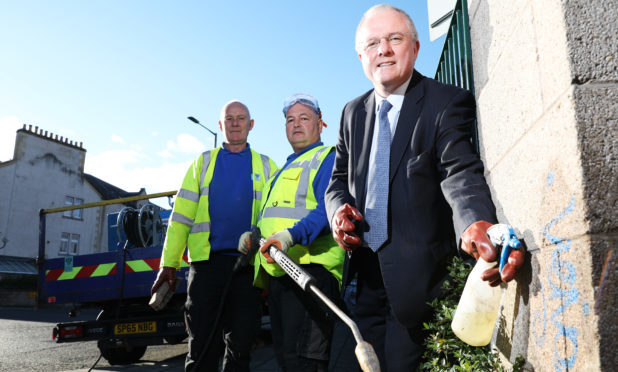 Peter Barrett helping clean up graffiti in the city.