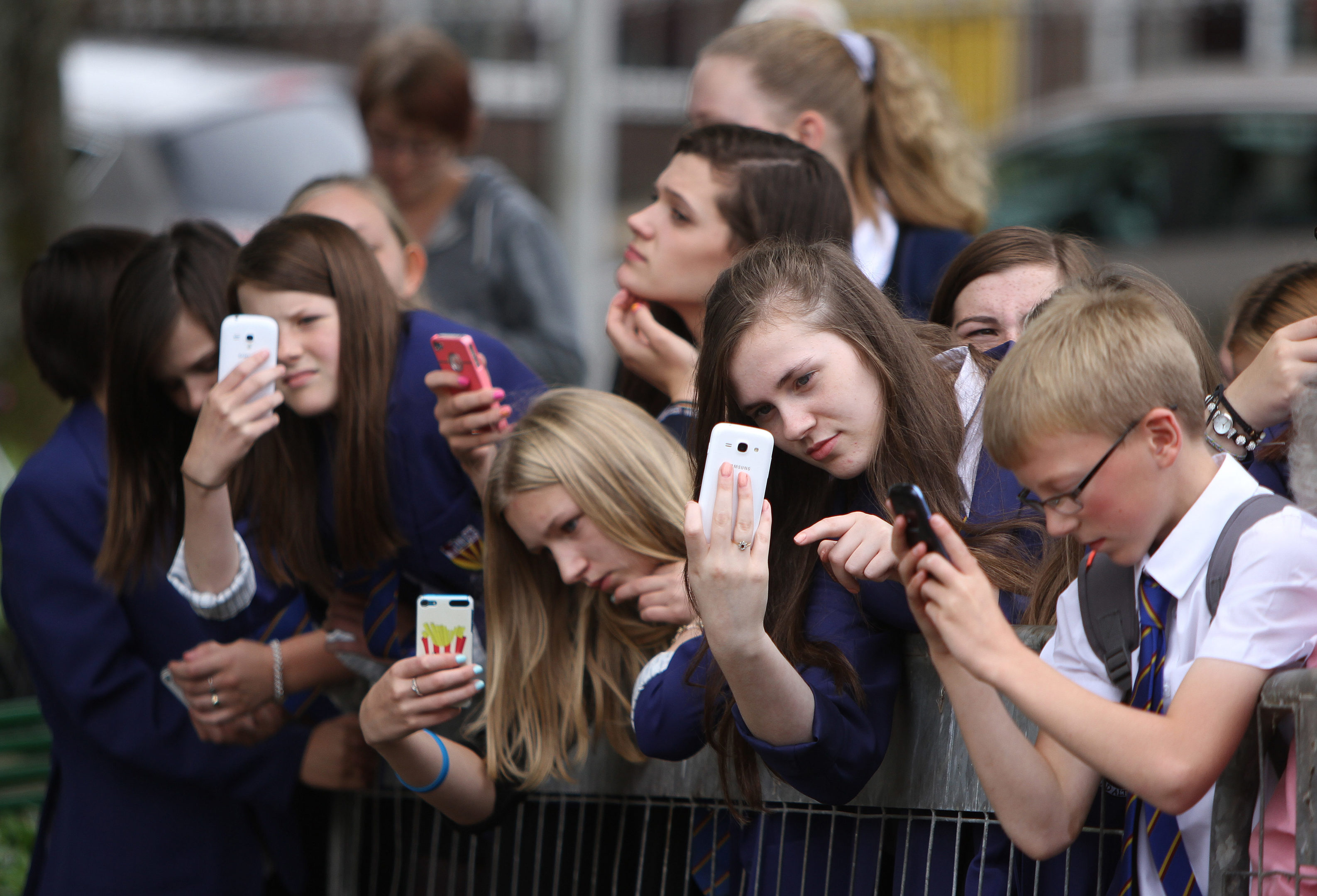 School children on mobile phones trying to get a picture of a statue unveiling in 2014.