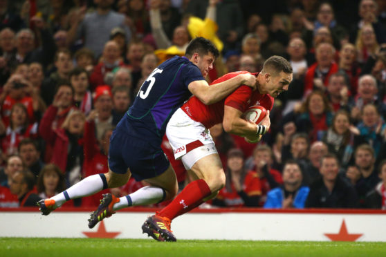 George North goes through for his side's first try despite Blair Kinghorn's tackle.