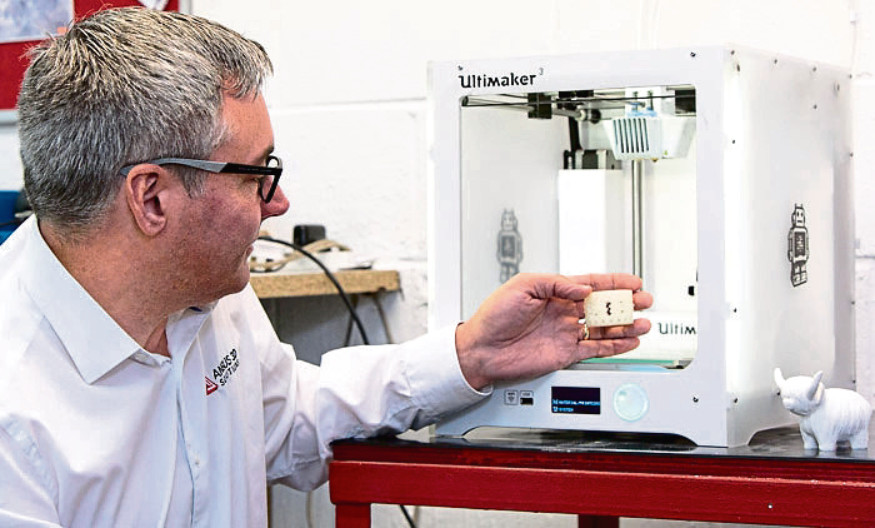 Andy Simpson, Managing Director of Angus 3D Solutions, checking a 3D-printed part.