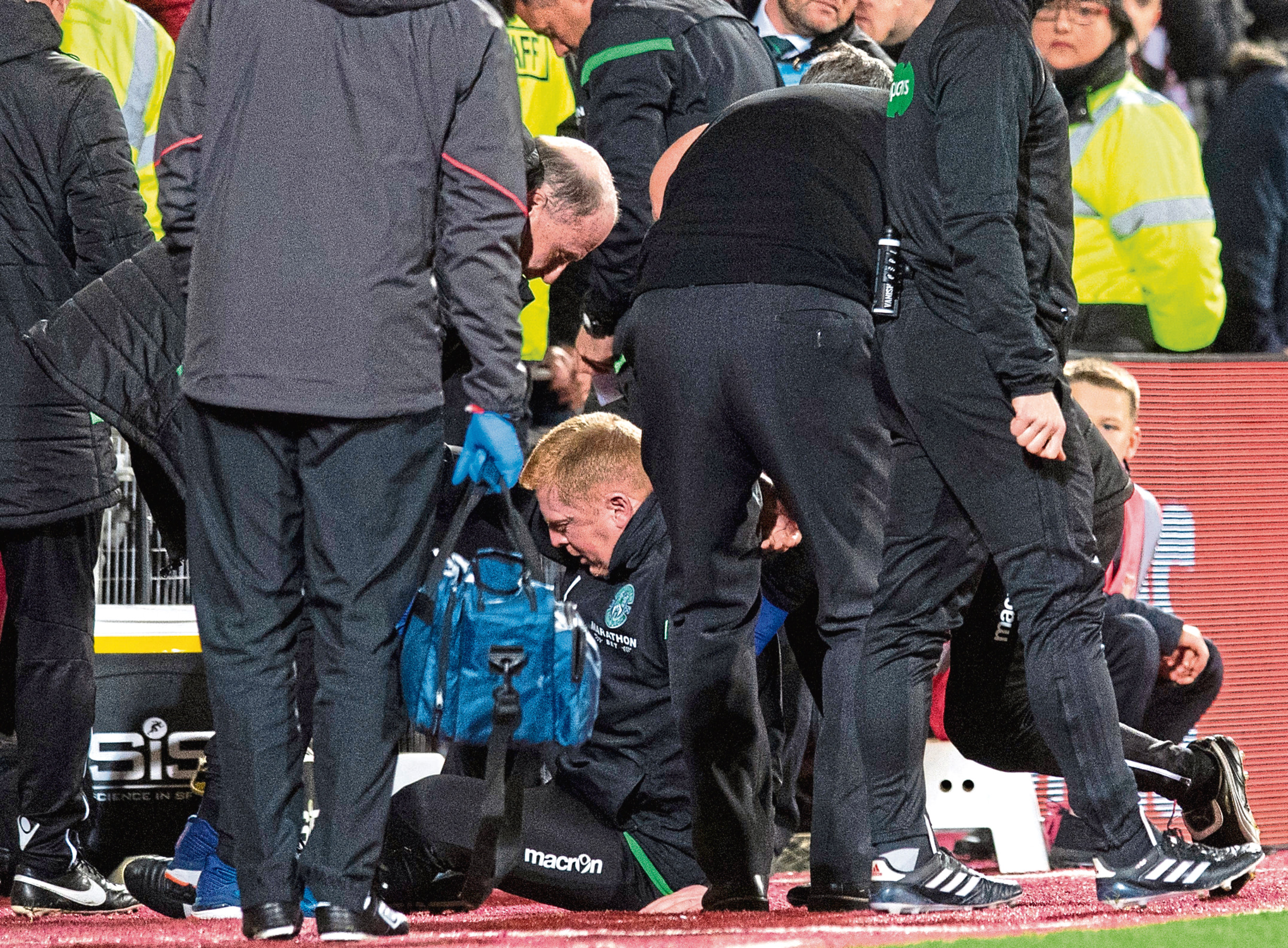 Hibernian manager Neil Lennon is helped to his feet by Hearts manager Craig Levein and a member of the Hibernian backroom staff after appearing to be struct by an object from the crowd during the Edinburgh derby.
