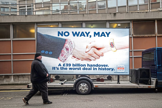 A man walks past an electronic billboard during the launch a new 'Leave Means Leave' campaign against British Prime Minister Theresa May's Brexit agreement on November 27, 2018.