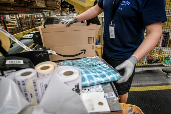 A worker boxes up some clothing ready for shipping.