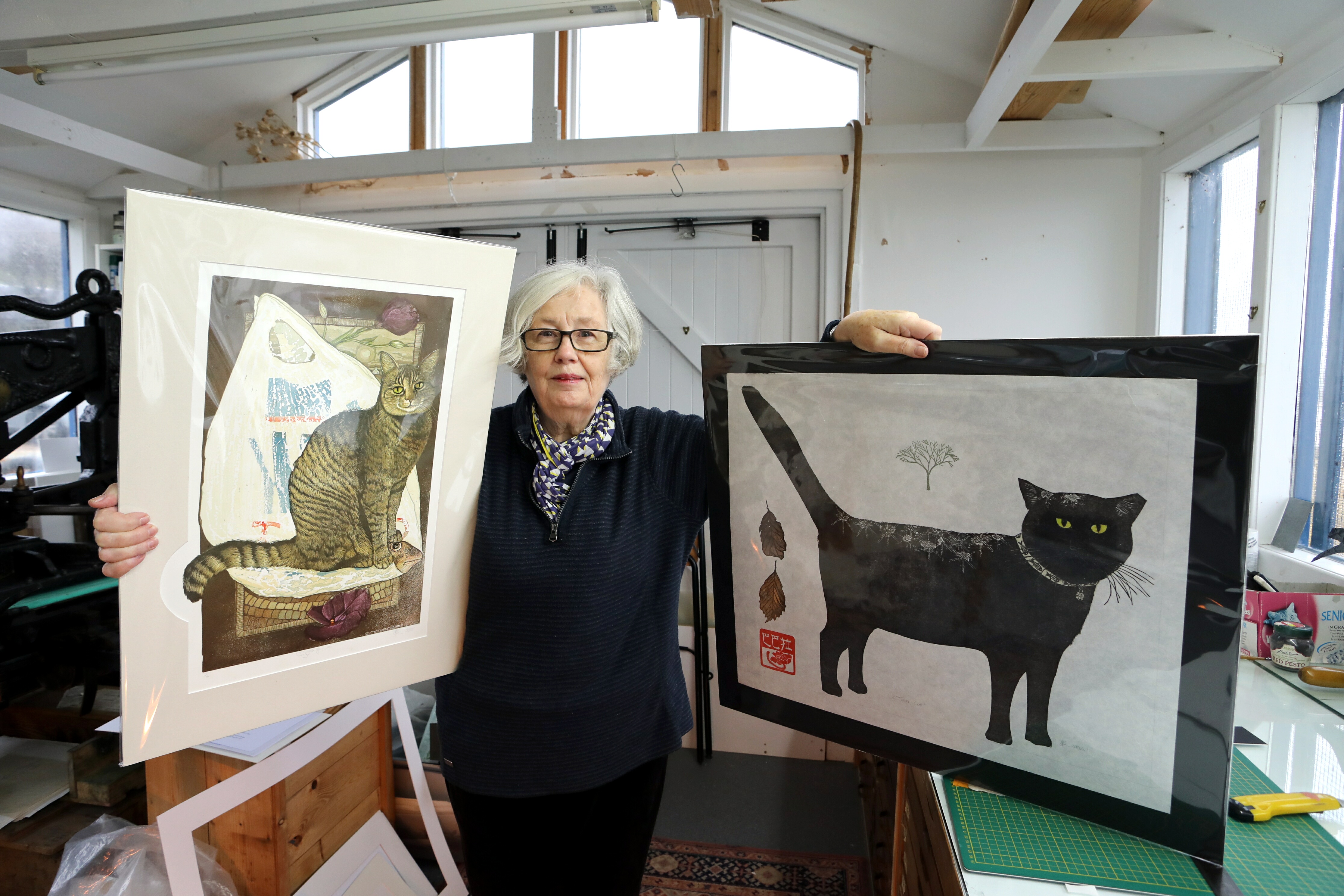 Sheila MacFarlane with two of Barbara Robertson's pieces of artwork entitled "Signs of Leo" and "Winter Cat".