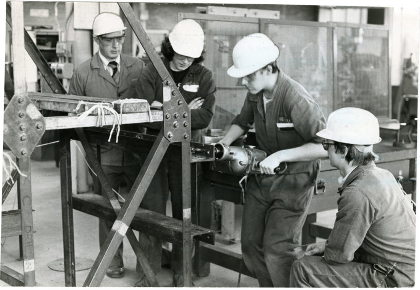 Technical instructor Mr Dave Adam with (from left) 12-year-old apprentices Sandy McIntosh, Garry McLeish, both from Dundee, and Brett Doward from Michelin's Aberdeen plant. Date: 22/04/1982.
