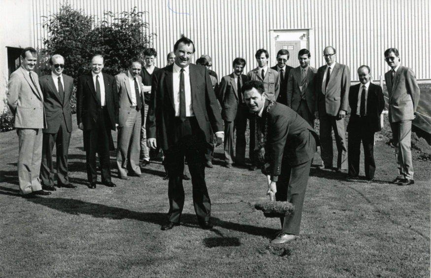 Lord Provost Tom Mitchell cuts the first sod at the Michelin Warehouse, watched by Mr Fraser Kyle, factory manager and other guests. Date: 19/8/87.