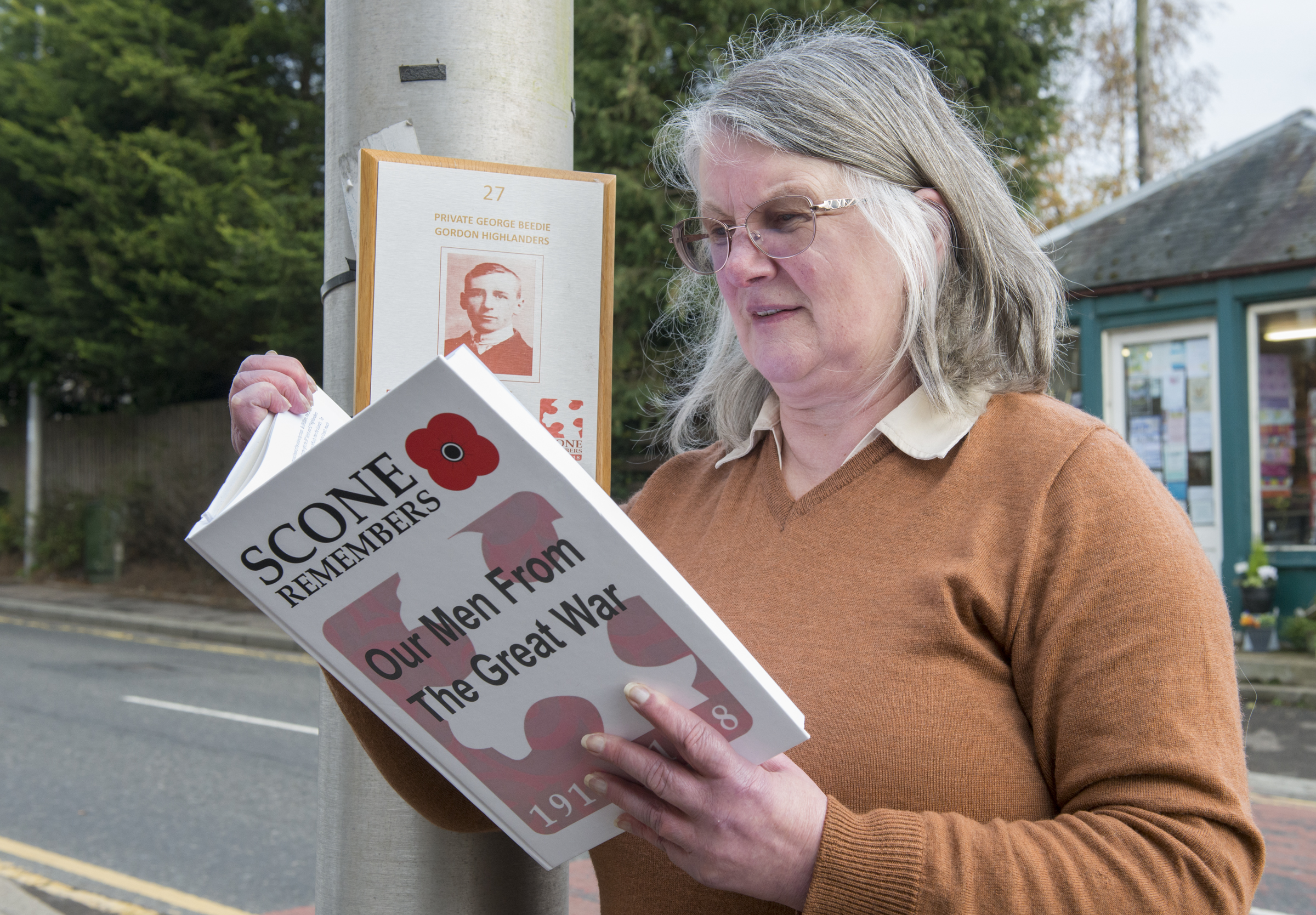 Scone shop owner Enid Davidson, is pictured with the book and plaque of her great uncle George Beedie, which is part of the memorial walk.