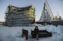 A  worker takes a break while working on ice sculptures. The massive and detailed snow sculptures and full-sized illuminated ice buildings attract over a million visitors a year to the north-eastern city of Harbin, where the cold Siberian wind plunges the average temperature to -13 degrees Fahrenheit (-25 degrees Celcius).