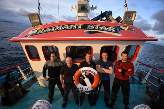 Jimmy Reid,Ian Couper, Victor Laurenson,Victor Duncan and Marven Inkster crew members of the Radiant Star, stand on deck during a days fishing in the North Sea on December 5, 2018 in Shetland, Scotland.
