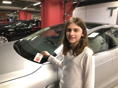 Charlotte placing one of the notes on an electric vehicle