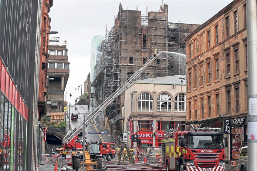 Fire fighters continue to dampen down following the fire at the Glasgow School of Art. Andrew Milligan/PA Wire