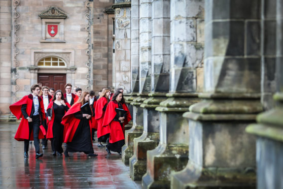 St Andrews University students in red gown at the chapel (St Salvator's Quad).
