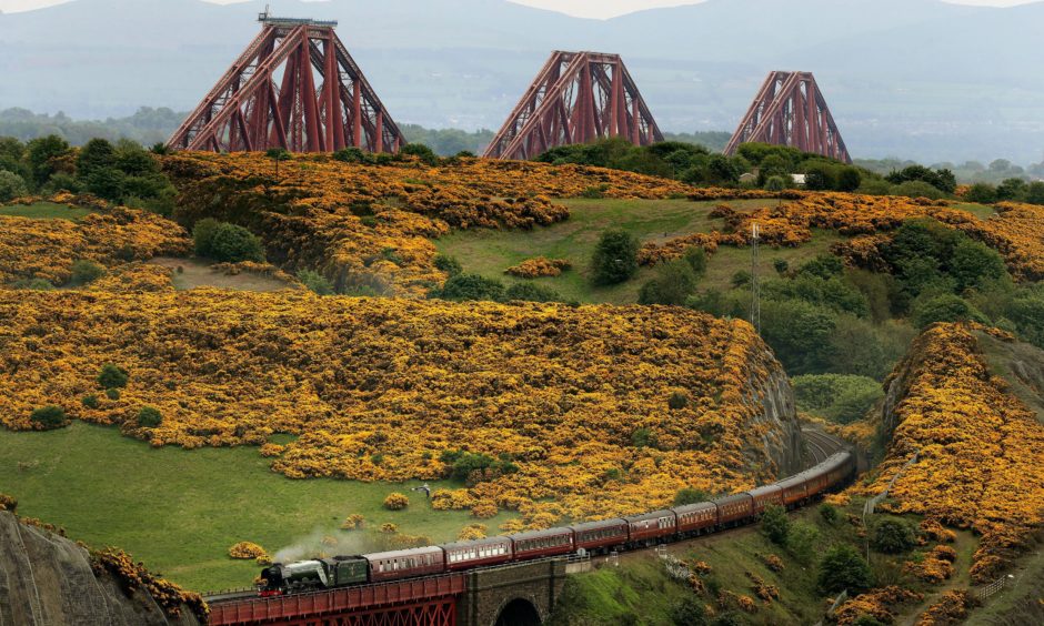 The Flying Scotsman steam train makes its way through the Fife countryside with the Forth Rail Bridge in the background. Andrew Milligan/PA Wire