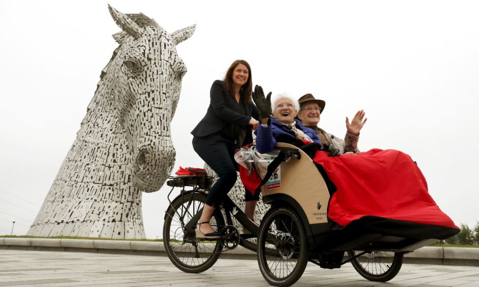 Public Health and Sport Minister Aileen Campbell pedals with Mary Duncan, 90, and Jim Taylor, 96, at the Kelpies in Falkirk. Andrew Milligan/PA Wire