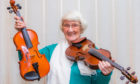 Jean Ferguson at home with the two fiddles