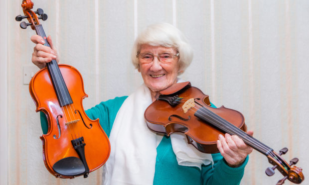 Jean Ferguson at home with the two fiddles