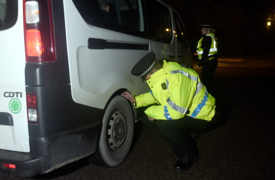 Police officers checking vehicles at a roadside in 2017.