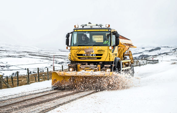 A gritter lorry clears a road.