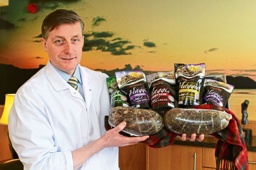 Simon Howie holding a selection of haggis products.