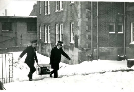 Police carry a portable generator into the house where the bodies were found.