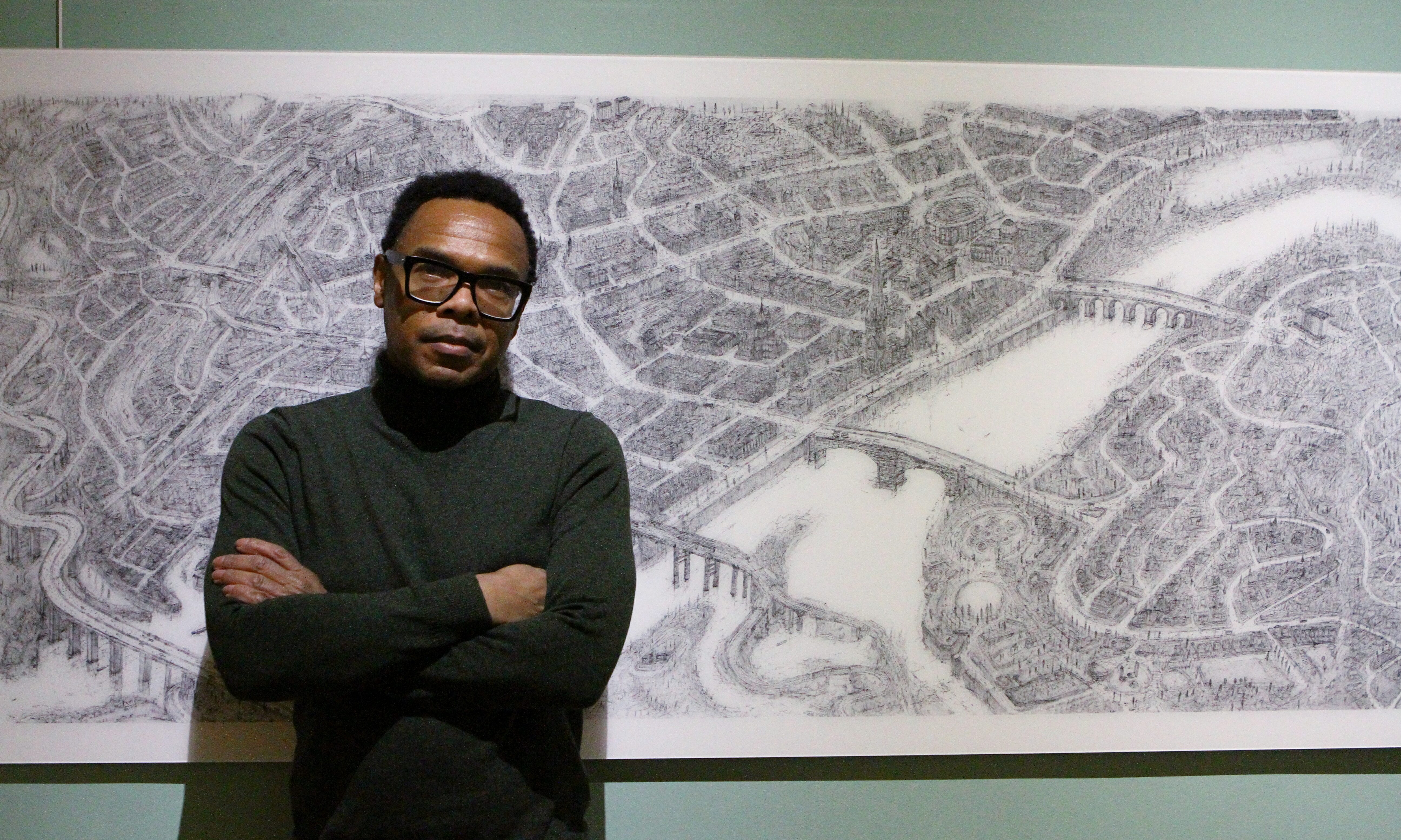 Artist Carl Lavia with a poster version of his drawing of the City of Perth.