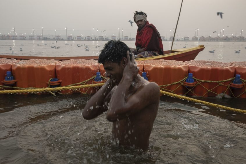 A devotee takes a holy dip at Sangam, the confluence of the rivers Ganges, Yamuna and mythical Saraswati.