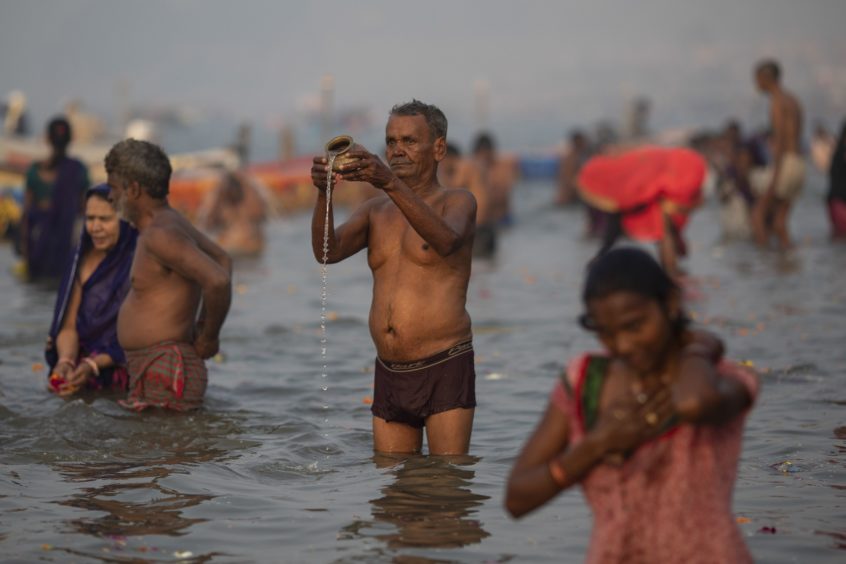 An Indian Hindu pilgrim prays at Sangam, the confluence of the rivers Ganges, Yamuna and mythical Saraswati, during the Kumbh Mela festival in Allahabad, India.