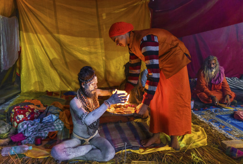 An Indian Naga Sadhu or a naked Hindu holy man prays inside his tent during Kumbh mela or pitcher festival at Sangam, in Prayagraj Uttar Pradesh state, India, . The Kumbh Mela is a series of ritual baths by Hindu holy men, and other pilgrims at Sangam, the confluence of three sacred rivers the Yamuna, the Ganges and the mythical Saraswati that dates back to at least medieval times. The city's Mughal-era name Allahabad was recently changed to Prayagraj. (