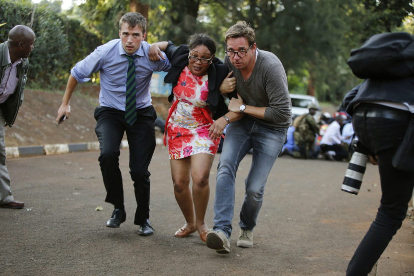 People take cover after an attack on a hotel, in Nairobi, Kenya.