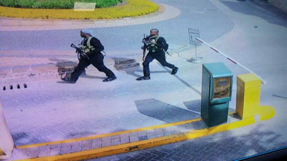 In this grab taken from security camera footage released to the local media, heavily armed attackers walk in the compound of a hotel