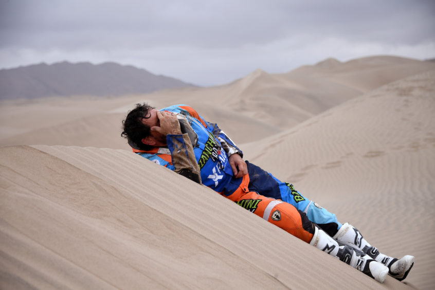 Marcos Colvero of Brazil lies on the dunes after he crashed on his KTM motorbike during the third stage of the Dakar Rally between San Juan de Marcona and Arequipa, Peru.
