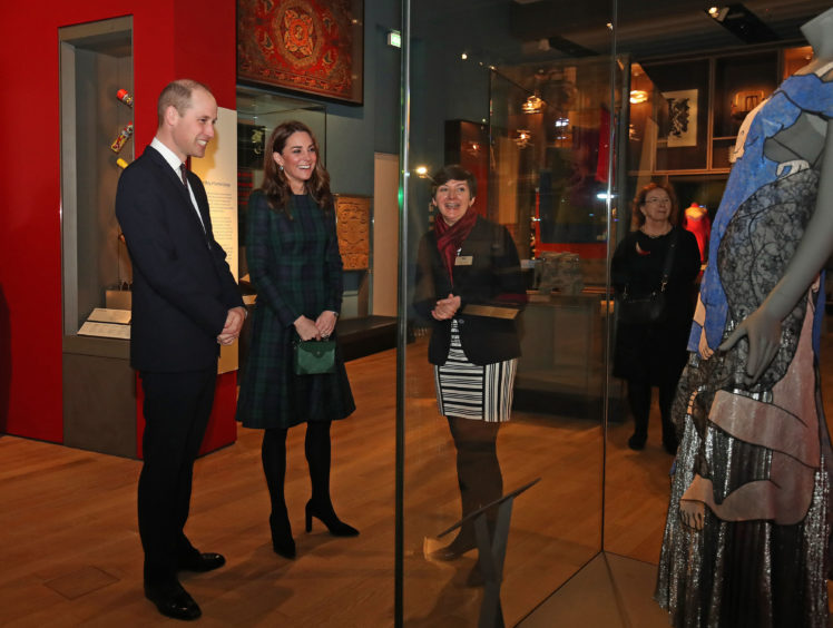 The Duke and Duchess with Senior Curator Joanna Norman look at a Christopher Kane dress. Jane Barlow/PA Wire