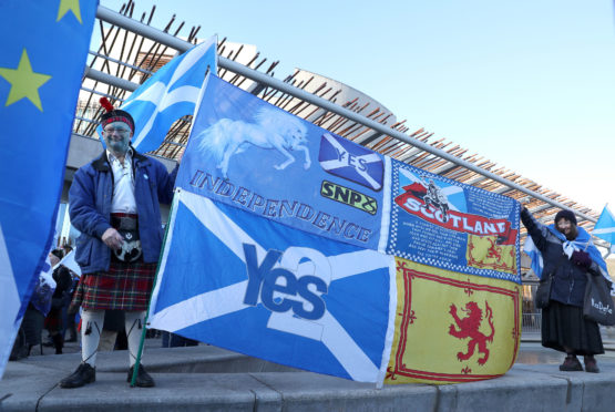 Campaigner John Love holds a banner at an Independence demonstration outside the Scottish Parliament in Edinburgh.