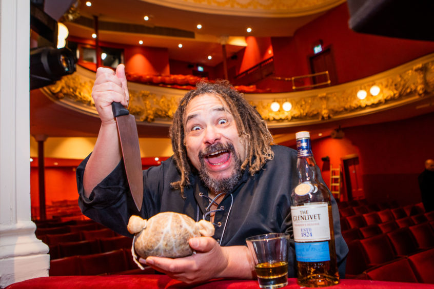 Bruce Fummey with a haggis, dagger and bottle of whisky