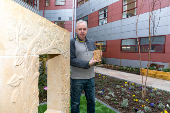 Stone carver Pete Reilly with his sculpture in the Queen Margaret Hospice Garden in Dunfermline.