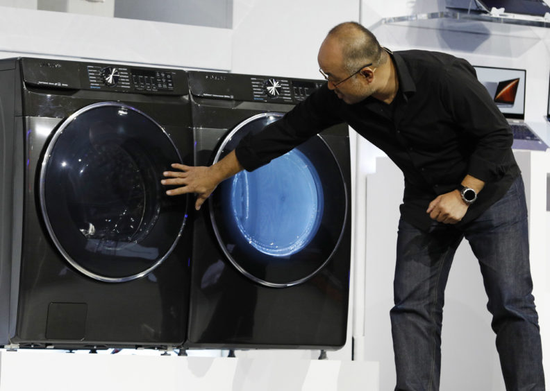 Yoon Lee, senior vice president, Samsung Electronics America, looks at a new front-load washer during a Samsung news conference.