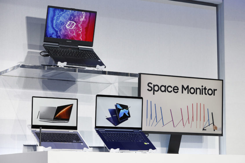 New computers and a monitor are on display during a Samsung news conference.