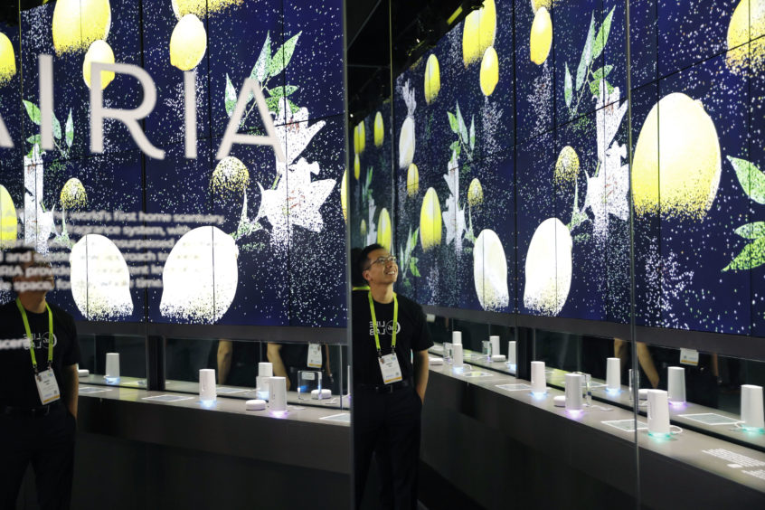 Thinh Ha stands in a display for Airia smart air fresheners at the Procter & Gamble booth.