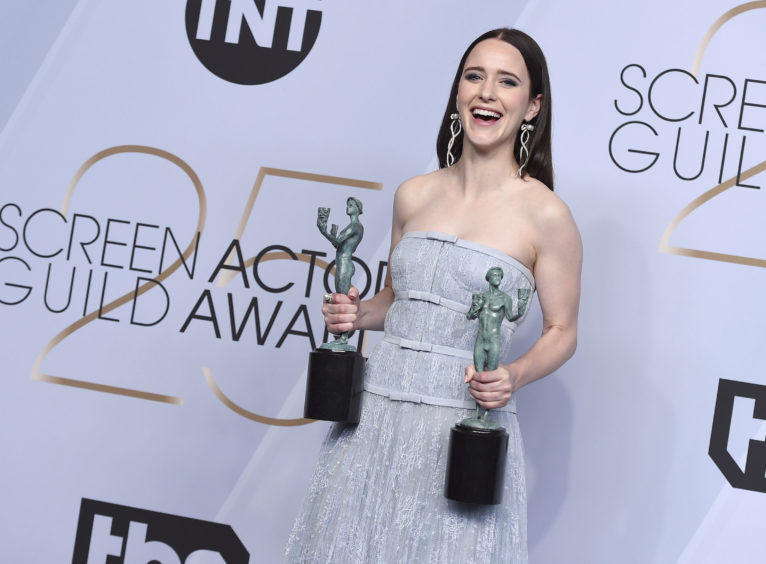 Rachel Brosnahan poses with the awards for Outstanding Performance by a Female Actor in a Comedy Series for The Marvelous Mrs. Maisel and for Outstanding Performance by an Ensemble in a Comedy Series for The Marvelous Mrs. Maisel.