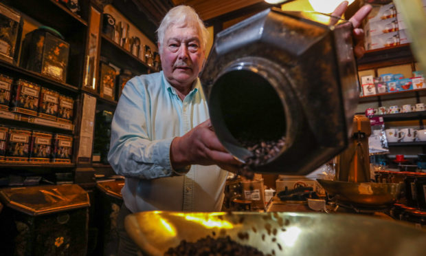 Allan Braithwaite measures out some coffee beans.